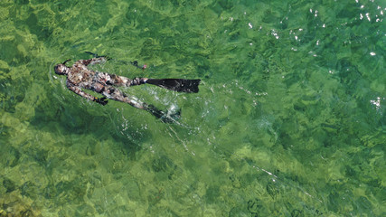 Aerial drone top view photo of spear fishing diver in tropical exotic emerald sea
