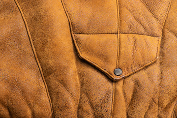 Background in the form of a fragment of the front of a winter jacket made of genuine brown leather
