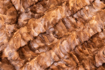 Background in the form of natural pieces of mink fur brown color located diagonally from left to right