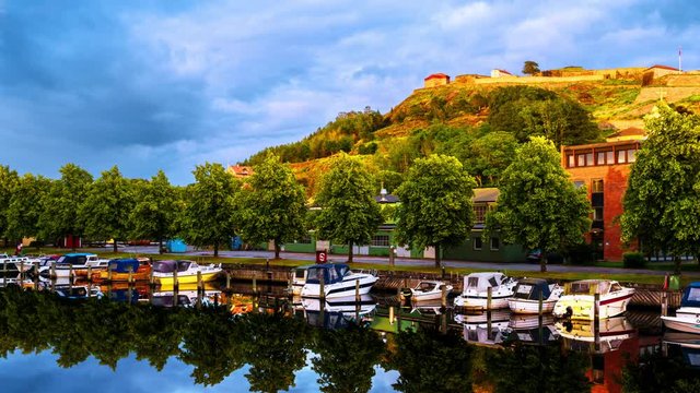 Halden, Norway. View of the boats and yachts with Fredriksted fortress at the background. Time-lapse in the evening with cloudy sky in summer, panning video