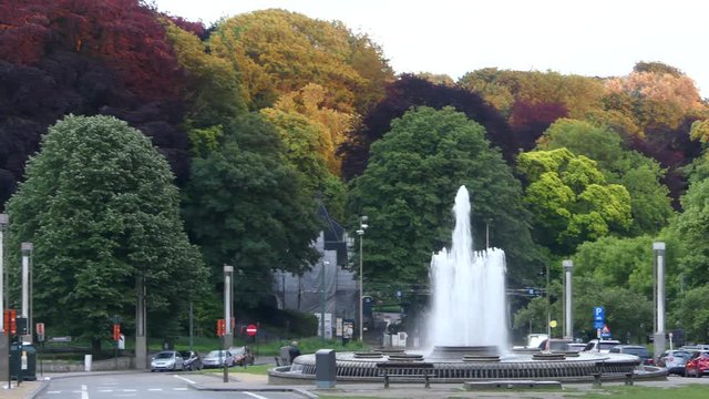 Fountain on the background of colorful trees in a park near the Atomium, an iconic building in Brussels.