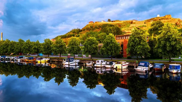 Halden, Norway. View of the boats and yachts with Fredriksted fortress at the background. Time-lapse in the evening with cloudy sky in summer, zoom in