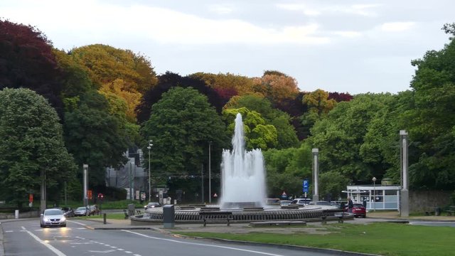 Fountain on the background of colorful trees in a park near the Atomium, an iconic building in Brussels.