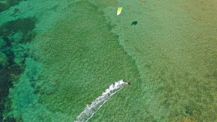 Aerial drone photo of kite surfer practising acrobatics in tropical exotic open ocean bay with emerald sea on a windy day