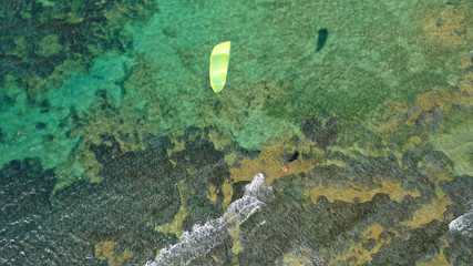 Aerial drone photo of kite surfer practising acrobatics in tropical exotic open ocean bay with emerald sea on a windy day