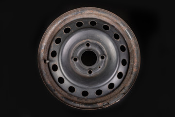 Obraz premium Old black metal rim on a workbench. Rusty car accessories.