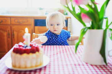 Happy baby girl in blue dress celebrating her first birthday