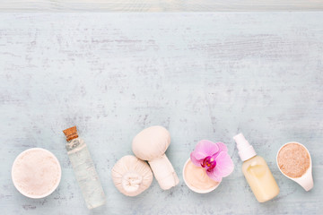 Sea salt, aromatherapy oil in bottles and orchid on vintage wooden background.