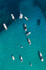 Fototapeta na wymiar View from above, stunning aerial view of a beautiful bay full of boats and luxury yachts. A turquoise sea bathes the green and rocky coasts. Liscia Ruja, Emerald Coast (Costa Smeralda) Sardinia, Italy