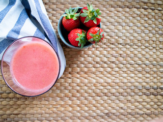 Smoothie made with forest fruit with a bowl filled wtih strawberries and a cloth - Powered by Adobe