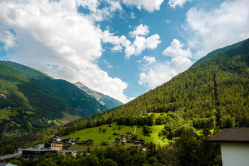 Fototapeta na wymiar Amazing view of the hillside village and green slopes of the Swiss Alps. Colorful summer view of village. Idyllic outdoor scene in Switzerland, Europe