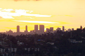 distant downtown towers in sunset glow with panoramic view of yellow sunrays on red glow