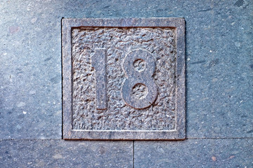 18, number eighteen, decorative numeral on gray surface.