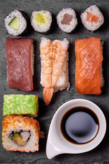 Sushi set with salmon, prawn, avocado and soy sauce on stone plate