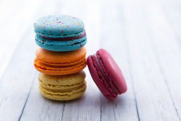 French crash macarons. Stack of colorful macaroon on wooden table