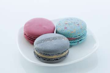 Assortment of different colored macaroons lies in a saucer with a top view