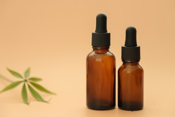 Dark glass bottles with full, cannabidiol oil and hemp leaves on a pastel background. Health conception. Medical marijuana.