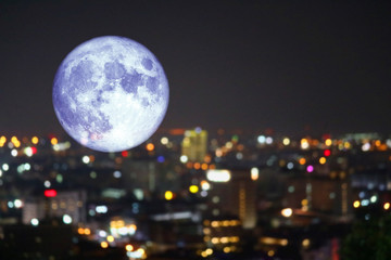 super super full harvest moon on night sky and reflection light of city on window