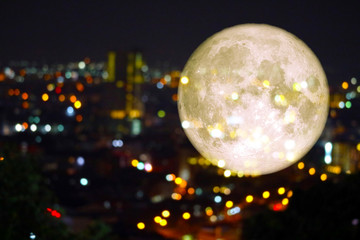 super super full harvest moon on night sky and reflection light of city on window