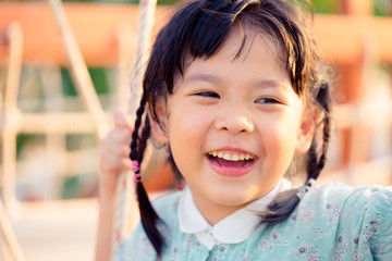 Asian child girl playing on playground in outdoor park.Happy Little asian girl playing swing with her mother.Happy moment and good emotion.