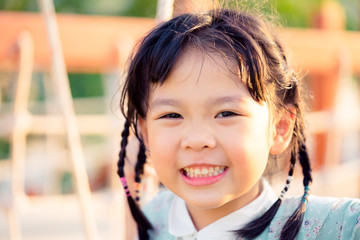 Asian child girl playing on playground in outdoor park.Happy Little asian girl playing swing with her mother.Happy moment and good emotion.