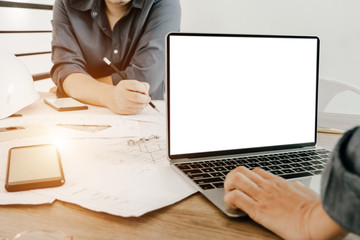 Fototapeta premium Mockup image of engineers using laptop to drawing design building Project in office, mockup concept