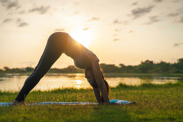 Fototapeta premium Young asian woman wearing exercise suit and stretching before play yoga on fitness mat in park, Healthy concept, Mind-body improvements concept.;