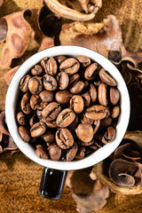 cup with coffee beans and rustic wooden background
