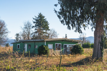 Old abandoned house in disrepair on sunny buy cold autumn day.