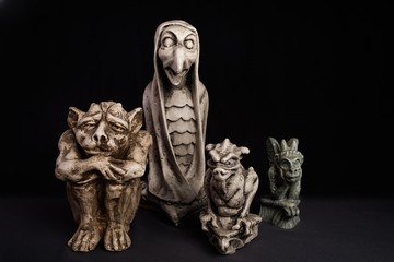 Fototapeta premium Gargoyle figurines on black and gray background.