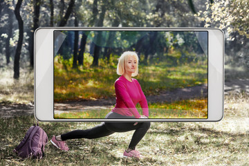 Photo of young fit woman stretching outdoor, demonstration of device capabilities