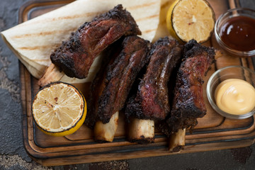Grilled beef ribs with tortillas and dipping sauces, selective focus, close-up