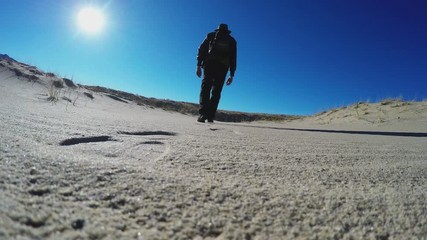 Ground Level View Hiker Walking Away In Sandy Desert