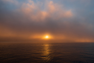 Foggy sunrise view over the water.