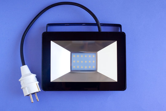 LED spotlight for street lighting, electric lamp on a blue background