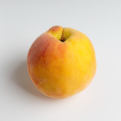 Ripe peach close-up on a white table