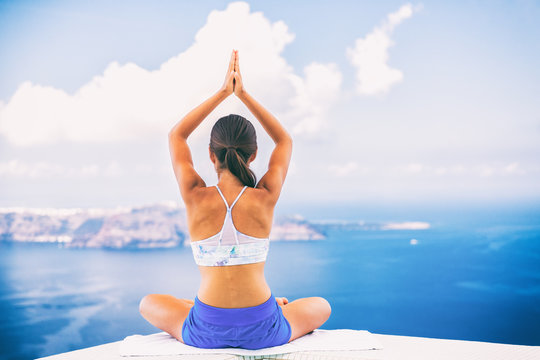 Woman doing yoga meditation in morning sunshine nature landscape- relaxing in beach background.