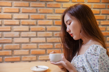 Asian women relax with hot coffee latte art with empty space .