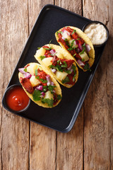 Mexican tacos al pastor served with sauce closeup on a plate. Vertical top view