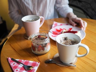mugs of cappuccino and desserts on wooden table