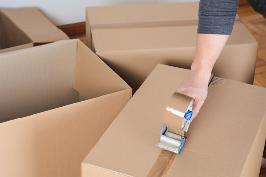 Man sealing a shipping cardboard box