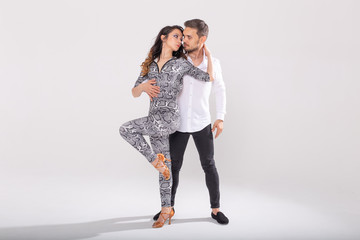 Social dance, kizomba, tango, salsa, people concept - beautiful couple dancing bachata on white...