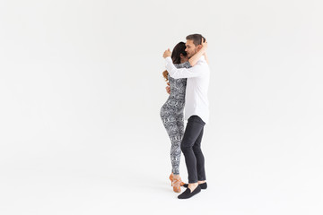 Skillful dancers performing in the white background with copy space. Sensual couple performing an artistic and emotional contemporary dance