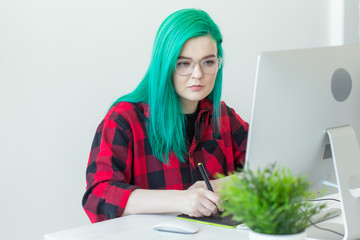 Designer, creative, people concept - green hair woman designer doing a project on a graphic tablet