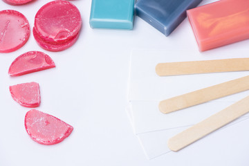 Red wax for depilation in tablets and cassettes, sticks and strips on a white background