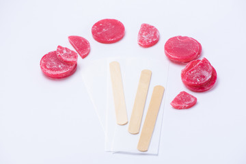 Red wax for depilation in tablets close up on a white background