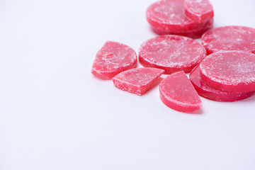 Red wax for depilation in tablets close up on a white background