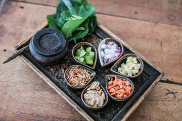 Thai Food Miang Kum Leaf-Wrapped Bite-Size Appetizer,A hand holdind a Leaf-Wrapped Bite-Size Appetizer. A Thai snack set of Wild Betel Leaf bush leave with ingredients chopped or cut into small pieces