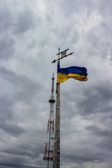 Obraz premium Ukraine flag waving on a background of gray sky with clouds.