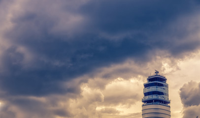 Airport traffic control tower at vienna International Airport on a dark cloud. Austria.